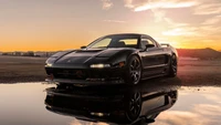 Elegante Acura NSX al atardecer reflejado en el agua, mostrando la herencia JDM