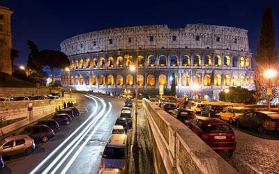 Colisée illuminé la nuit : Un aperçu des ruines emblématiques de la Rome antique au cœur de la ville