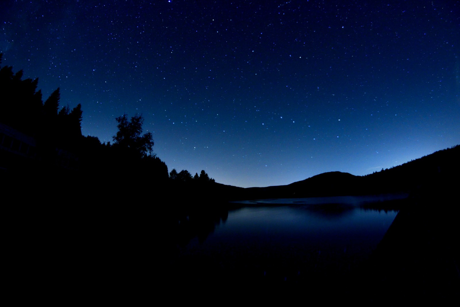 A view of a lake with a mountain in the background (light, blue, reflection, sky, night sky)