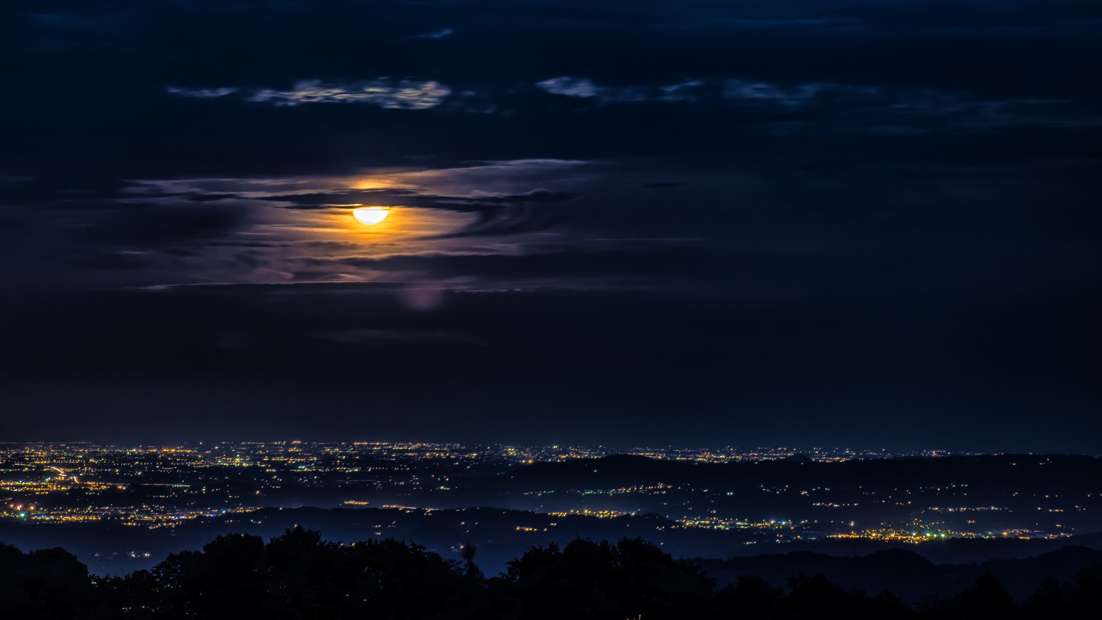 Ein voller mond über den lichtern einer stadt bei nacht (nacht, stadt, ansicht, landschaft, mond)