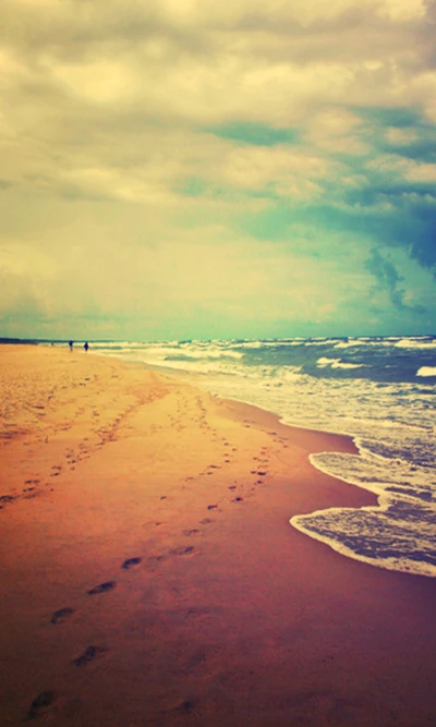 Tranquil Shoreline with Footprints and Gentle Waves