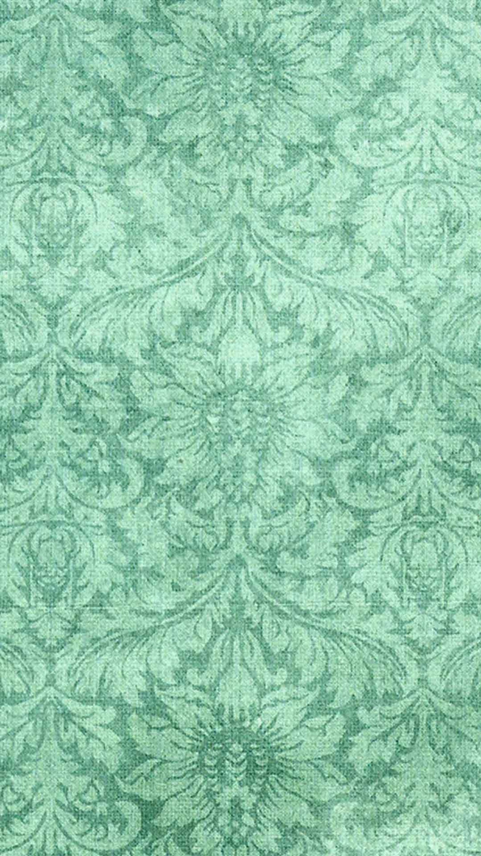 A close up of a green rug with a pattern on it (back, pattern)