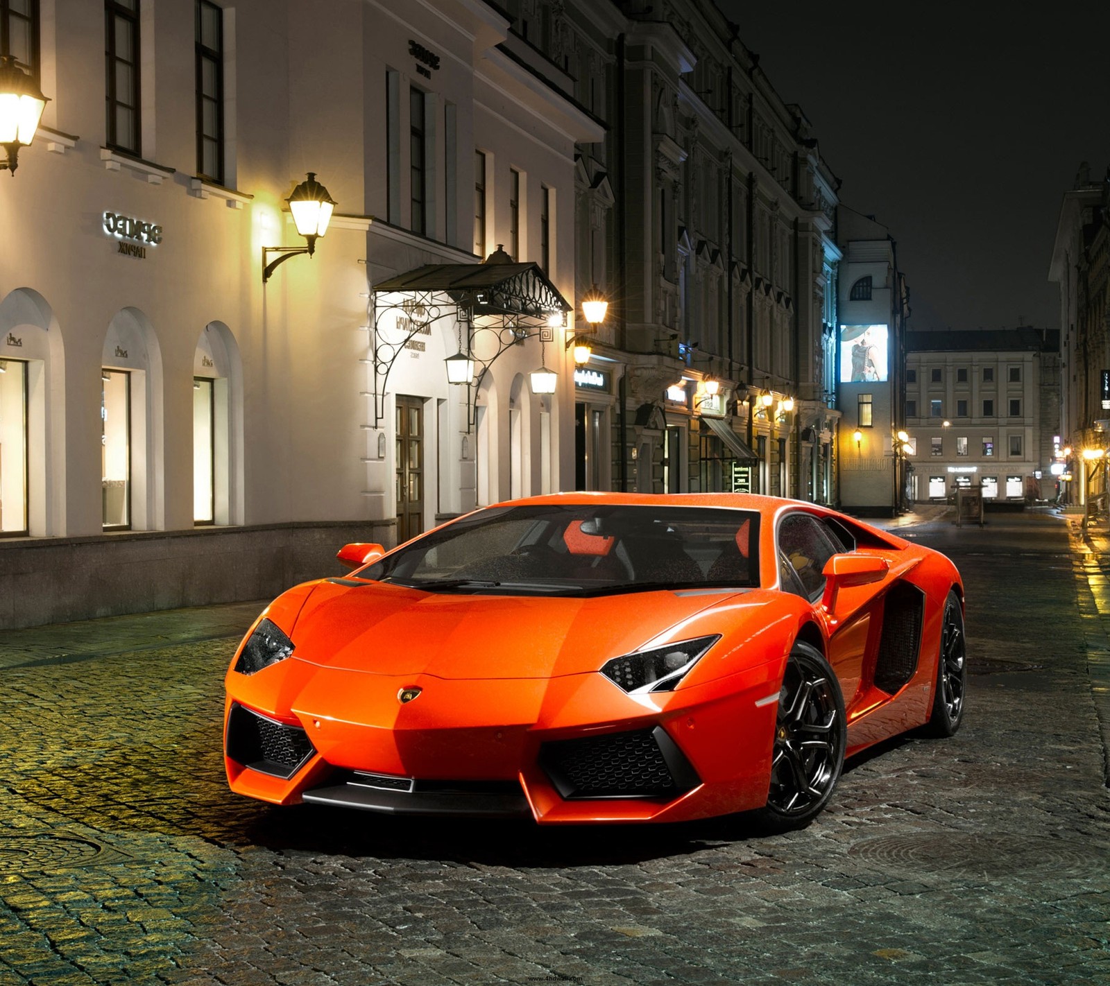 A close up of a red sports car parked on a cobblestone street (cars, lamborghini)