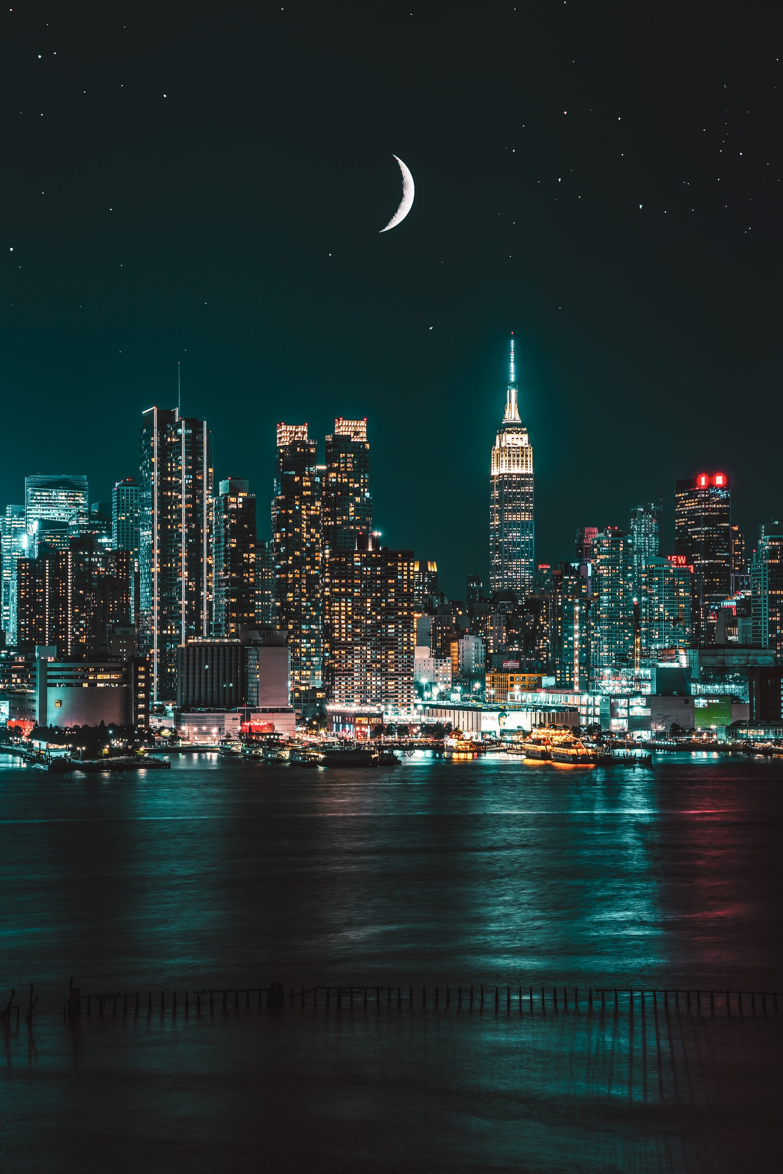 Vista noturna do horizonte da cidade com uma lua crescente sobre a água (nova york, new york city, arranha céus, night photography, paisagem urbana)