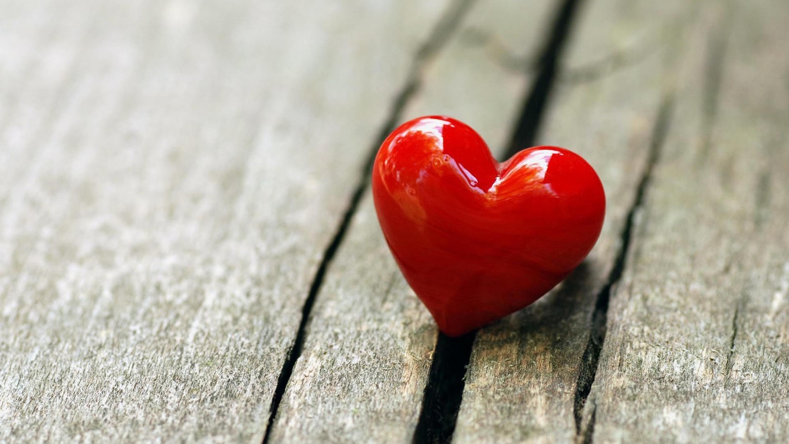 Un cœur rouge est posé sur une table en bois (romance, cœur, rouge, amour, gros plan)