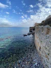 Paysage côtier avec des eaux azur et des murs en pierre historiques