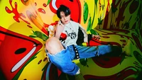 Jeno of NCT Dream in vibrant, colorful setting, showcasing a bold fashion statement.