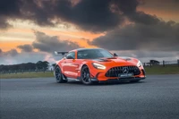 2021 Mercedes AMG GT Black Series em laranja marcante contra um fundo dramático de pôr do sol