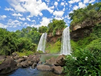 Iguazú-Wasserfälle: Ein majestätischer Wasserfall, umgeben von üppiger Vegetation und klarem blauen Himmel.