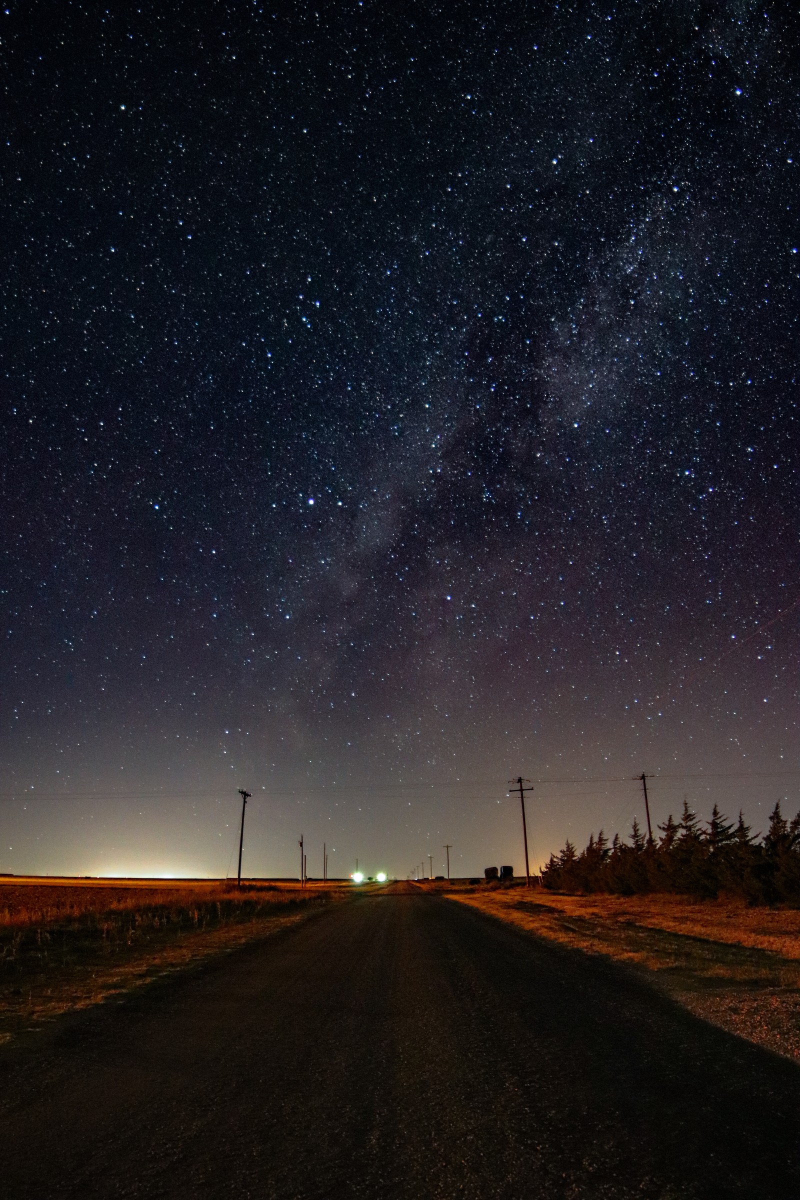 Vista aérea de uma estrada com um carro dirigindo à noite (céu, noite, estrelado, paisagem, nebulosa)