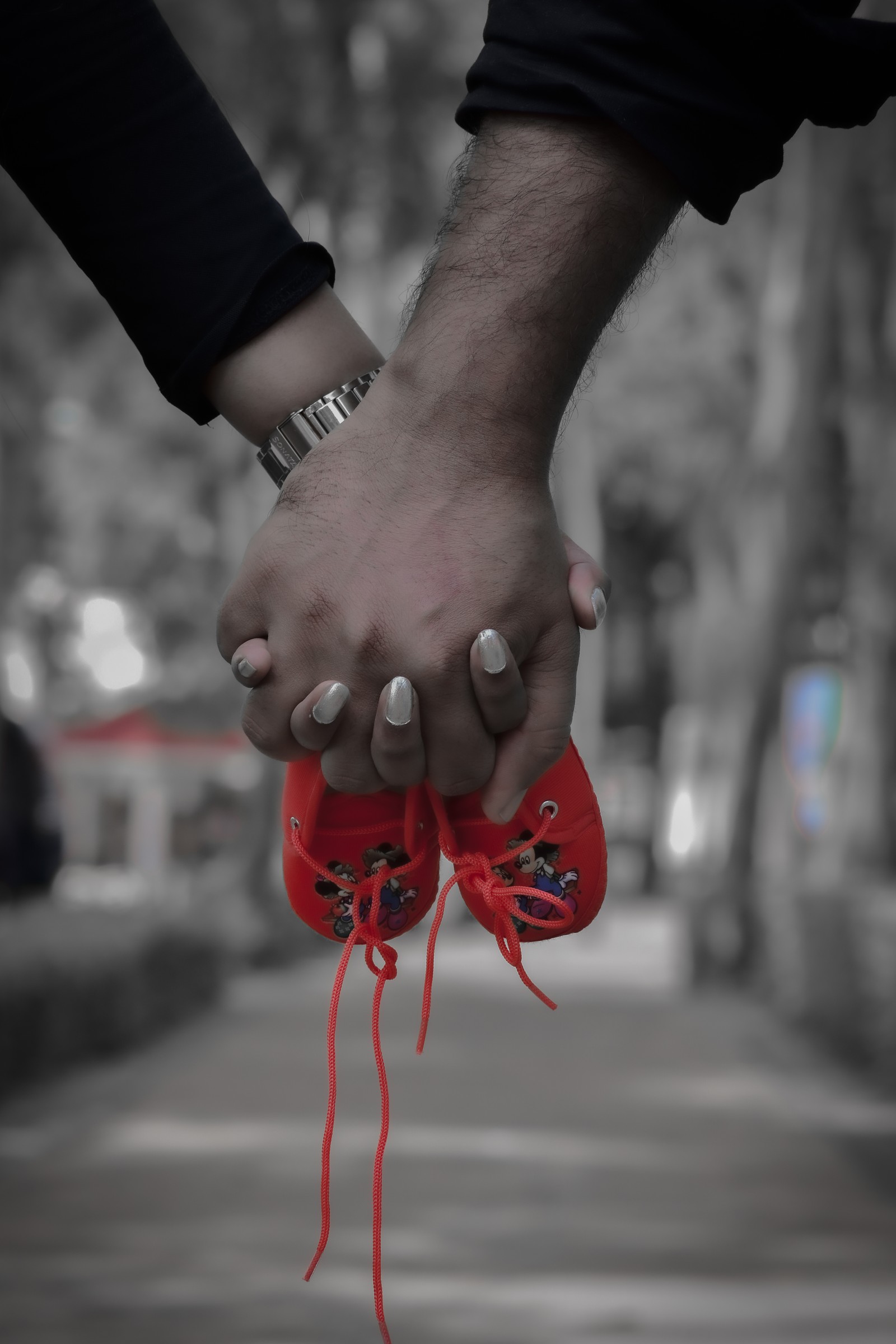 Une personne tenant une paire de chaussures rouges avec un lacet rouge (bébé, concept, mignon, justborned, enfant)