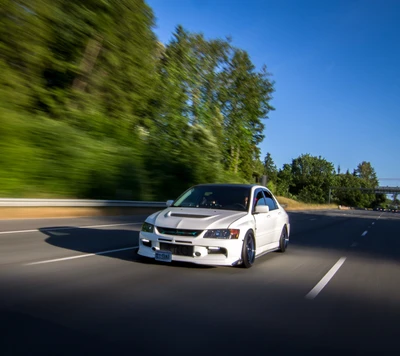 Mitsubishi Lancer Evo en mouvement sur une route pittoresque