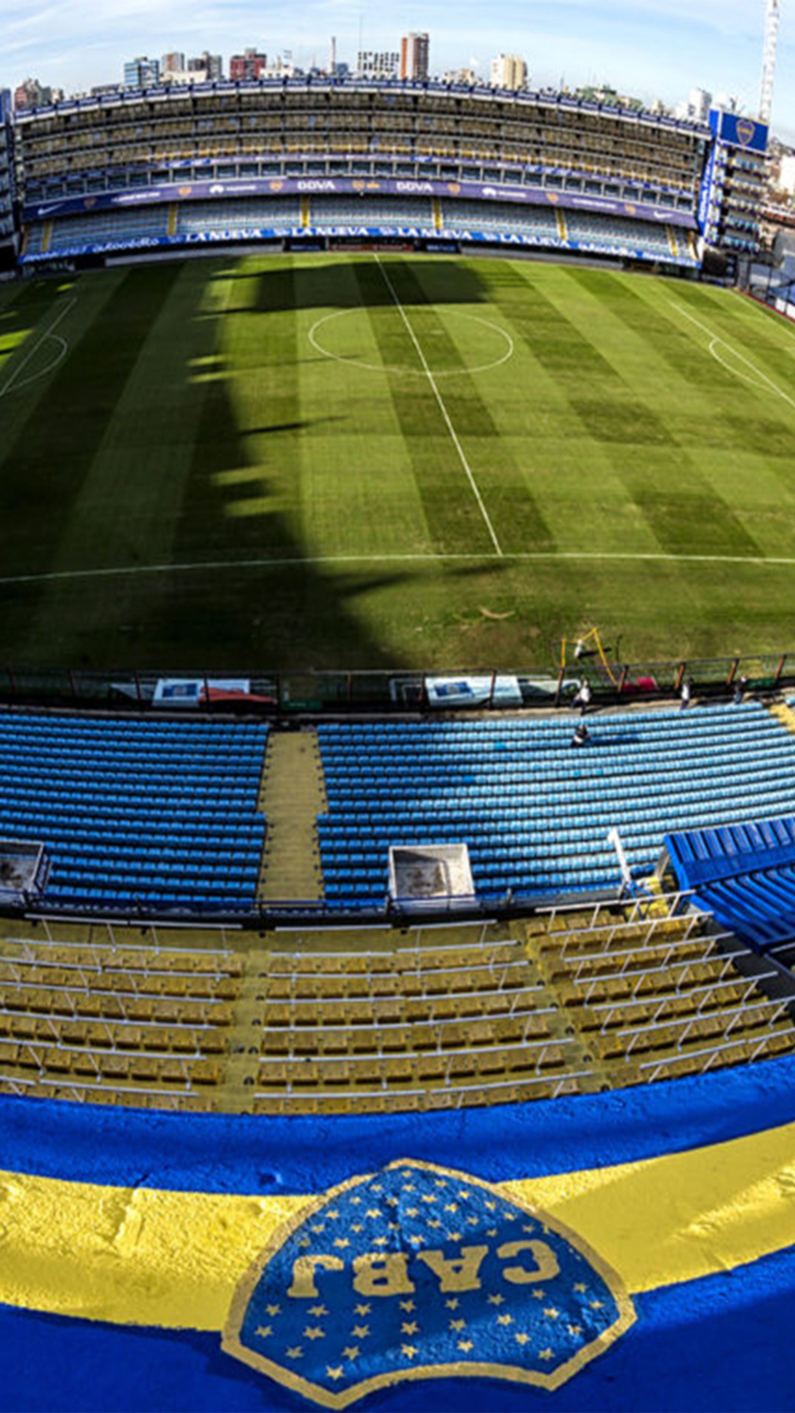 Uma vista próxima de um estádio de futebol com um campo e um campo azul e amarelo (boca, júnior, boca juniors, futebol, futbol)