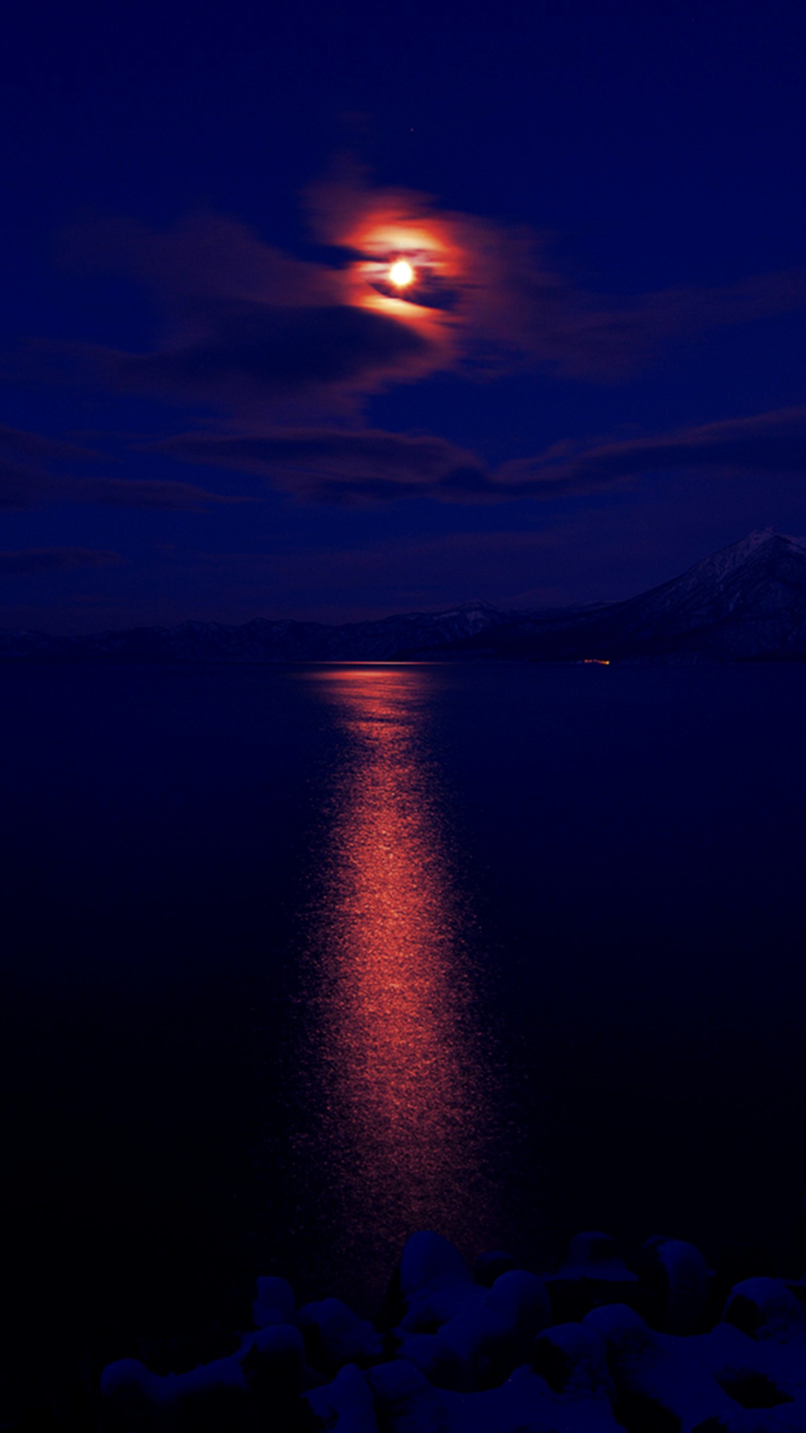 Vista árabe de uma lua cheia sobre um lago com pedras (escuro, luz do luar)