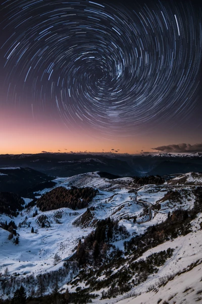 Trilhas de estrelas sobre os Dolomitas cobertos de neve ao anoitecer