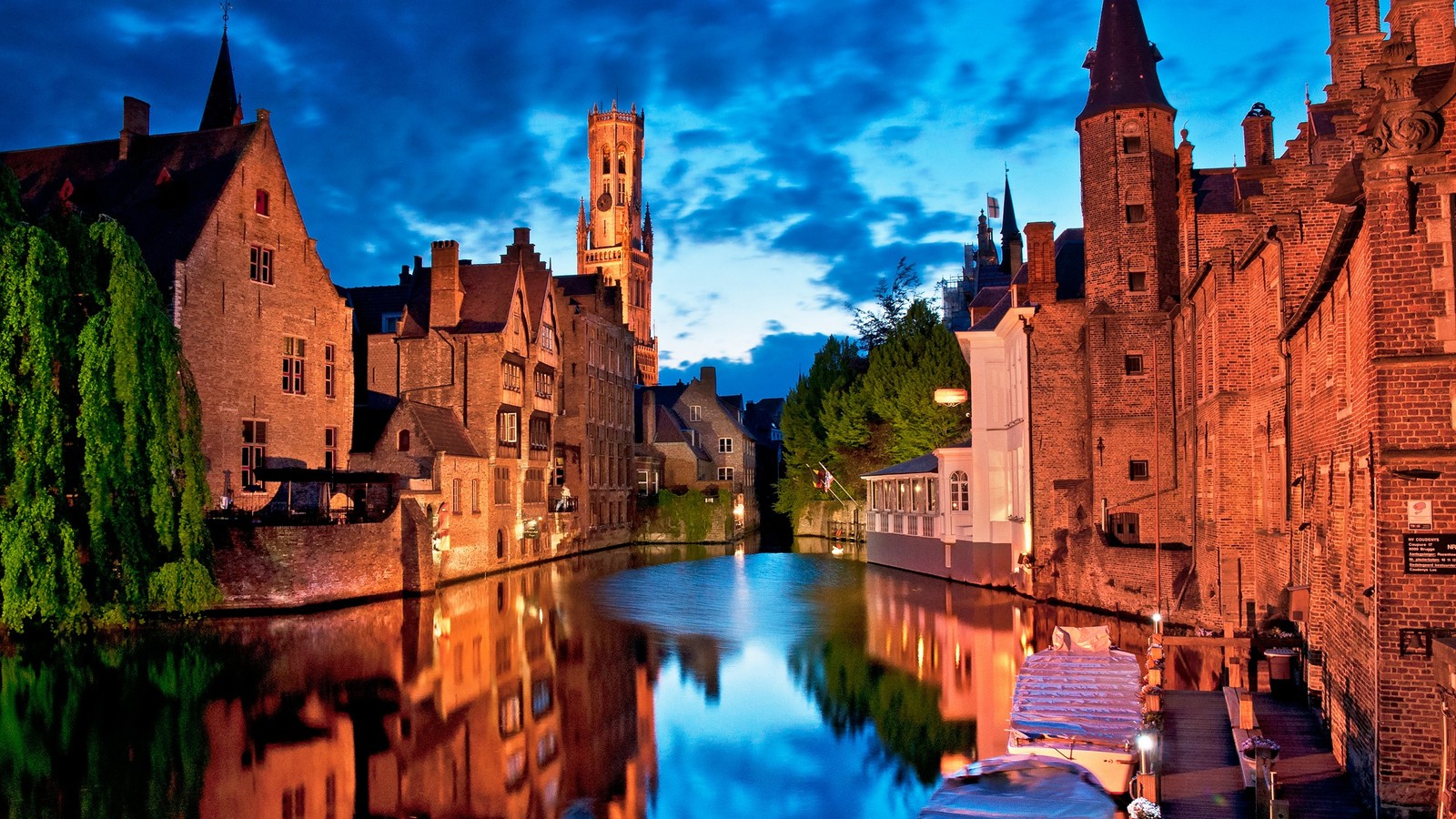 Luftaufnahme eines kanals mit booten im wasser und einer kirche im hintergrund. (wasserstraße, reflexion, stadt, wahrzeichen, mittelalterliche architektur)