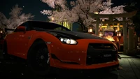 Nissan GT-R Amid Cherry Blossoms: A Stunning Sports Car in a Nighttime Cityscape.