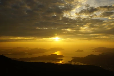 Lever de soleil doré sur l'horizon montagneux de Hong Kong