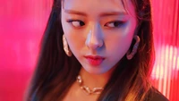 Yuna from ITZY in a vibrant and colorful scene from the "Wannabe" music video.