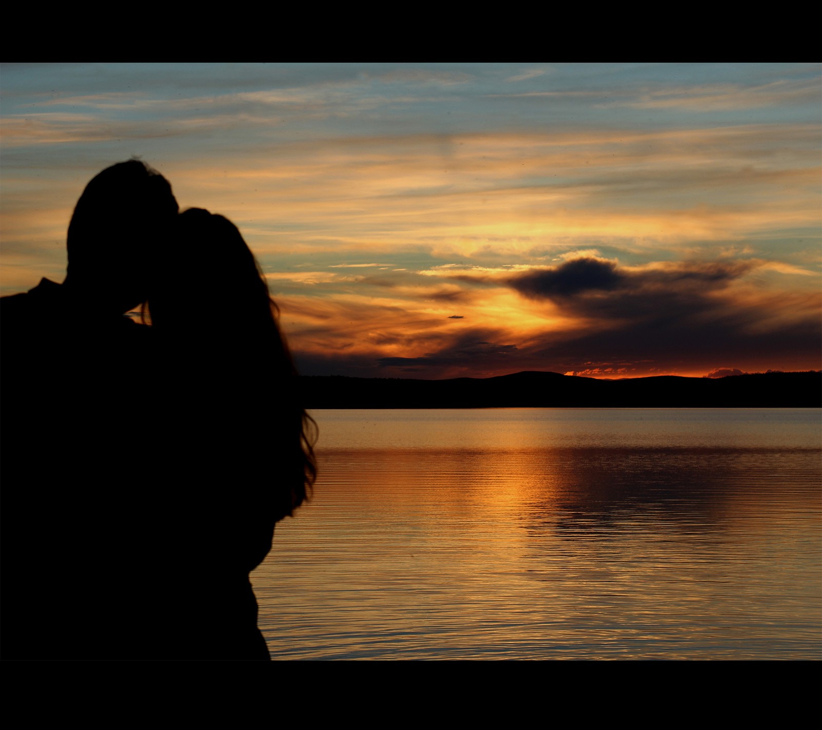 Una imagen borrosa de una pareja besándose frente a un atardecer (pareja, finlandia, ivalo, amor, fotografía)