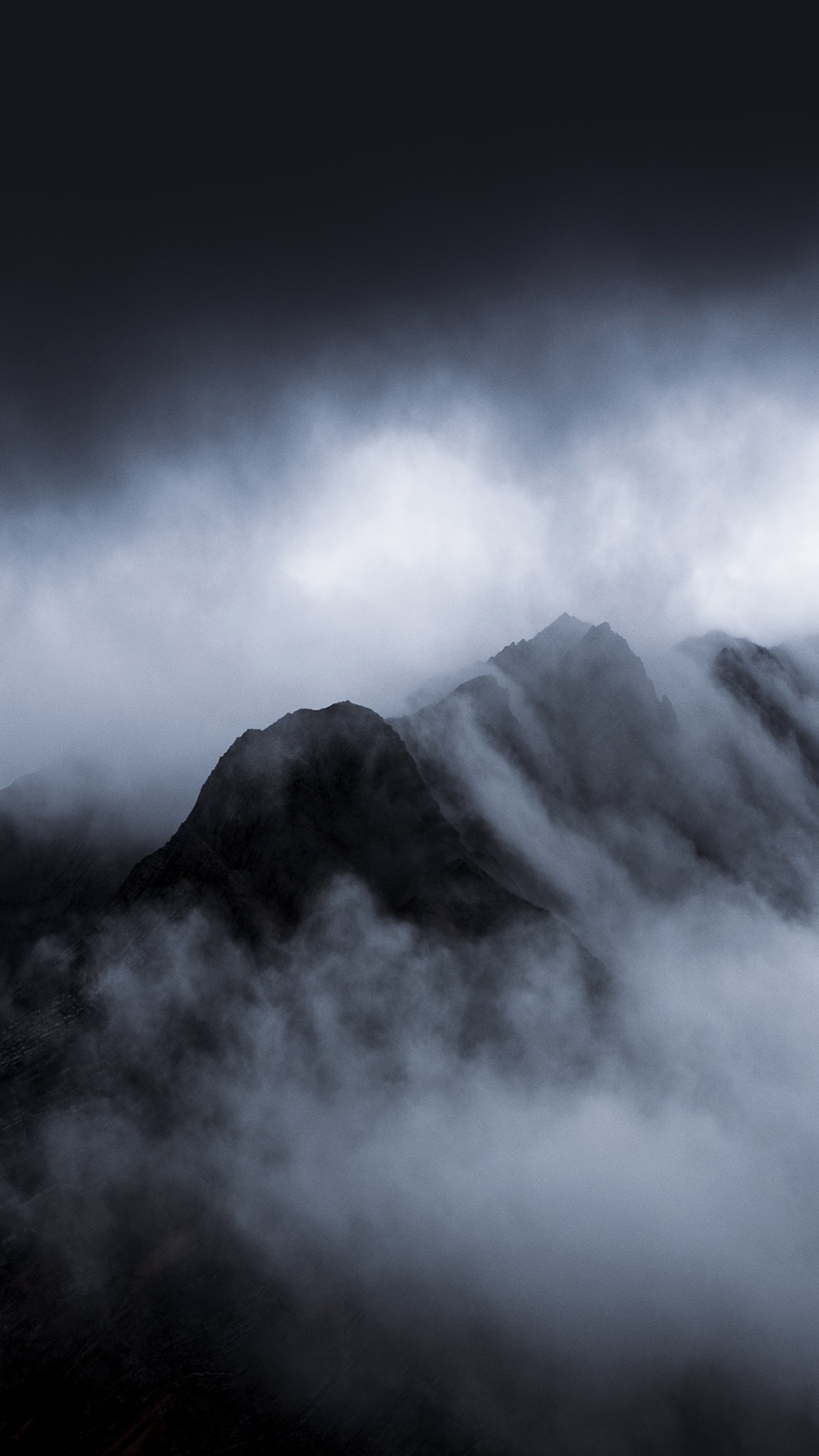 Il y a un avion qui vole à travers les nuages au-dessus d'une montagne (nuage, atmosphère, montagne, brume, crépuscule)