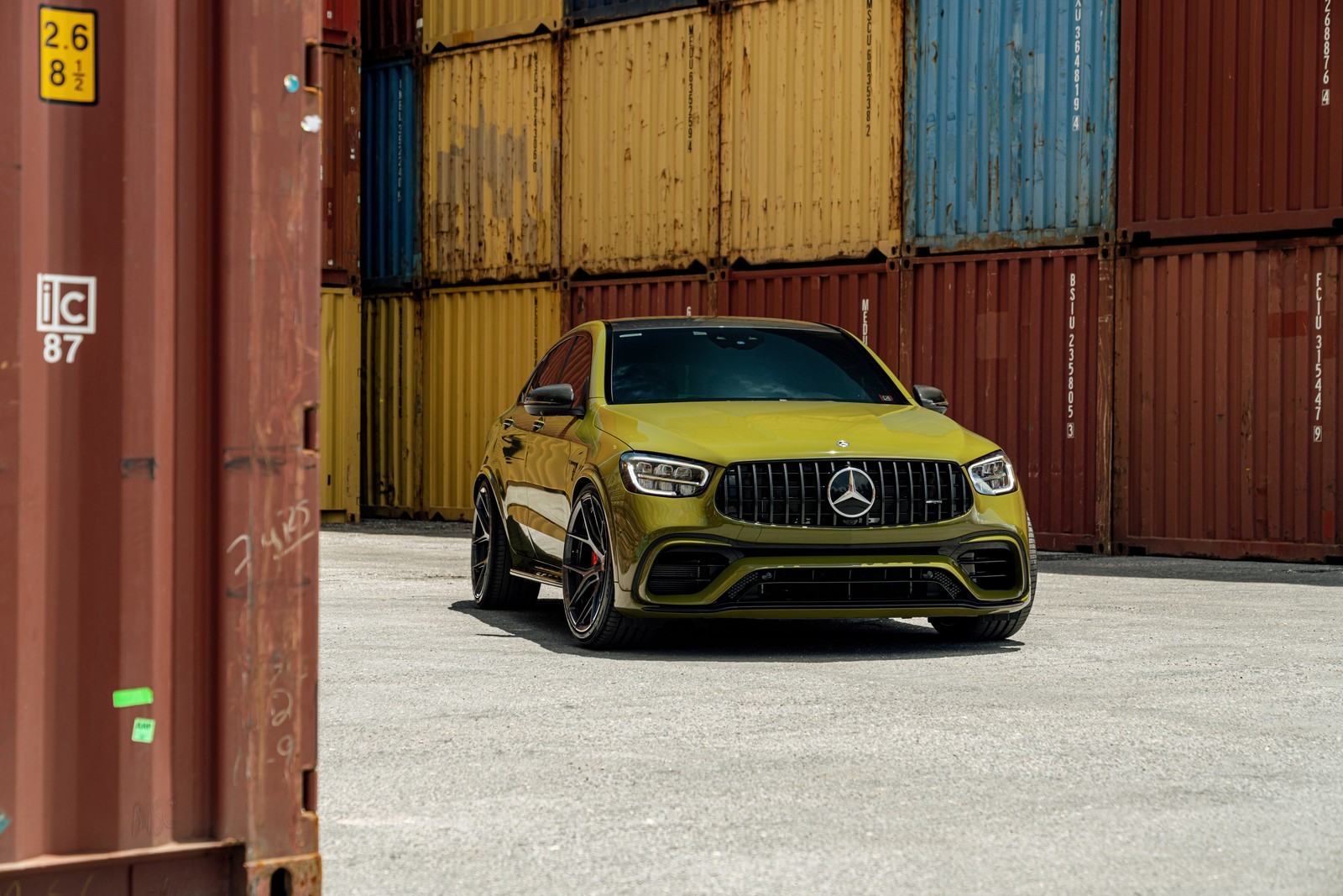 A close up of a yellow mercedes suv parked in front of a shipping container (mercedes amg glc 63, 5k, 8k, cars, 4k wallpaper)