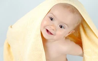 Joyful Infant Wrapped in a Yellow Towel