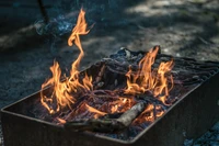 Lueur d'un feu de camp avec des flammes dansantes et des braises