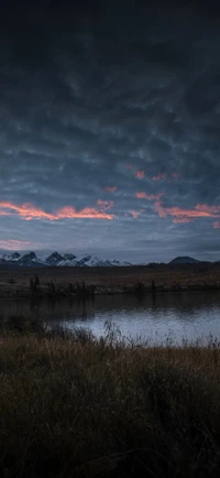 Crépuscule serein sur un lac tranquille avec des montagnes enneigées