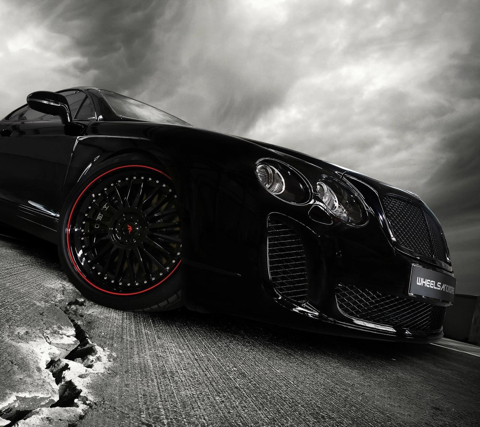 A close up of a black sports car parked on a road (bentley, car)