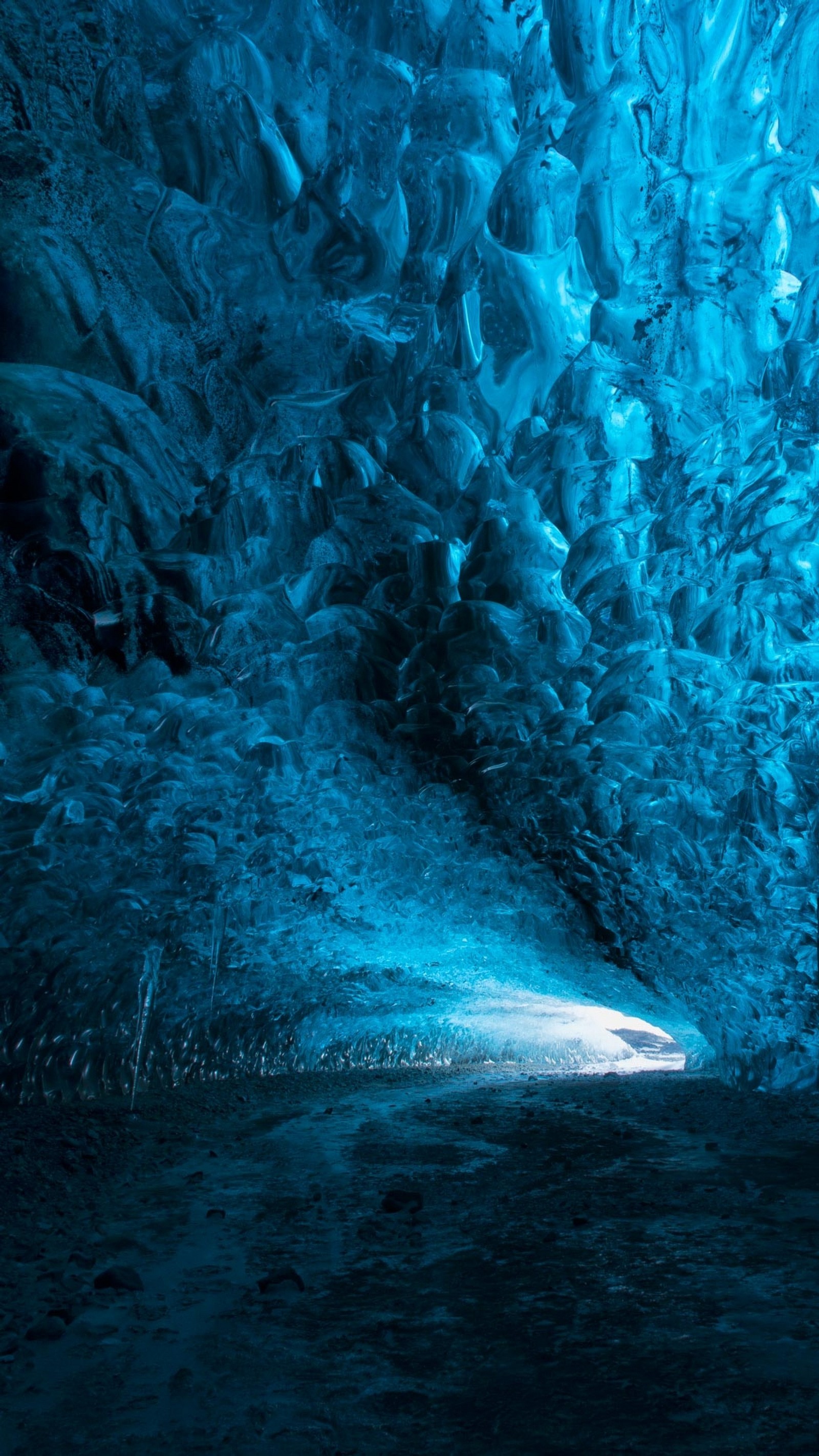 Une grande grotte de glace avec une lumière au bout (grotte, motte, glace, nature)