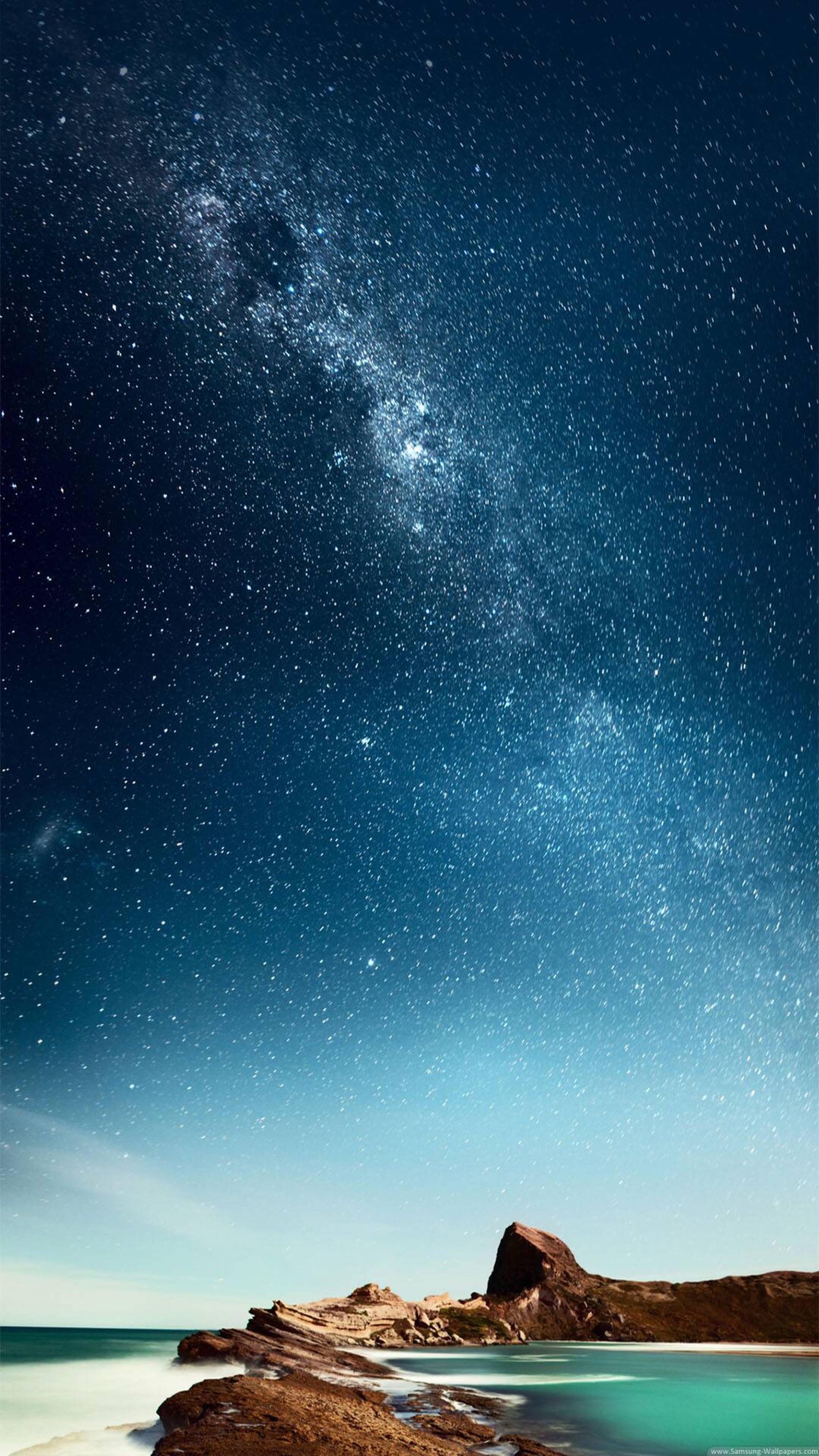 Cielo estrellado sobre una playa y un cuerpo de agua (naturaleza, azul, noche, paisaje natural, atmósfera)