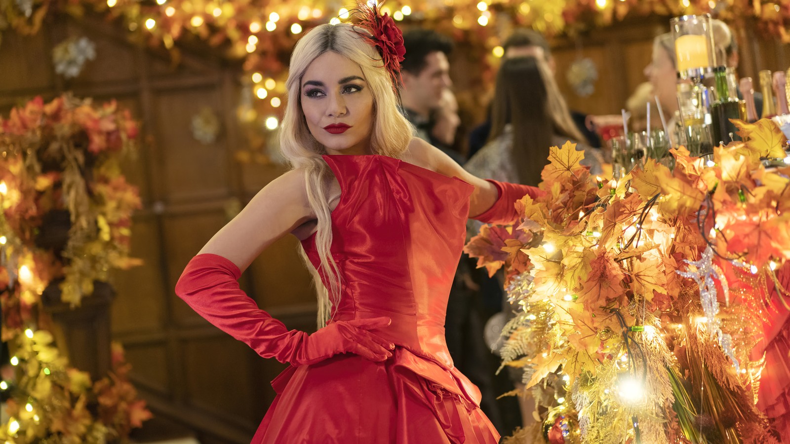 Femme arabe en robe rouge se tenant devant un sapin de noël (la princesse de chicago 3, romance avec létoile, 2021, film, vanessa hudgens)