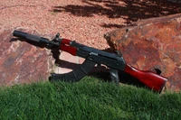 Rifle Airsoft AK-74 com silenciador na grama