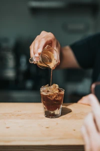 Creación de café helado: vertiendo espresso sobre hielo