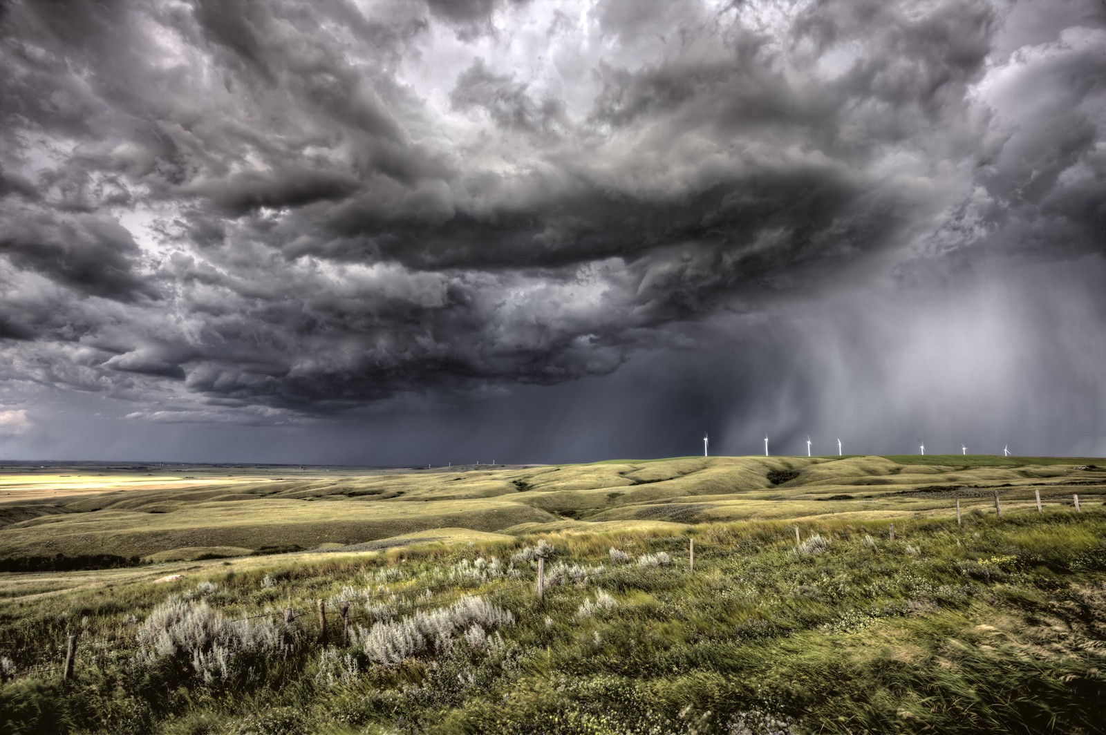 Un grand nuage d'orage arrive sur un champ avec des éoliennes (tempête, nuage, météo, prairie, gestion)