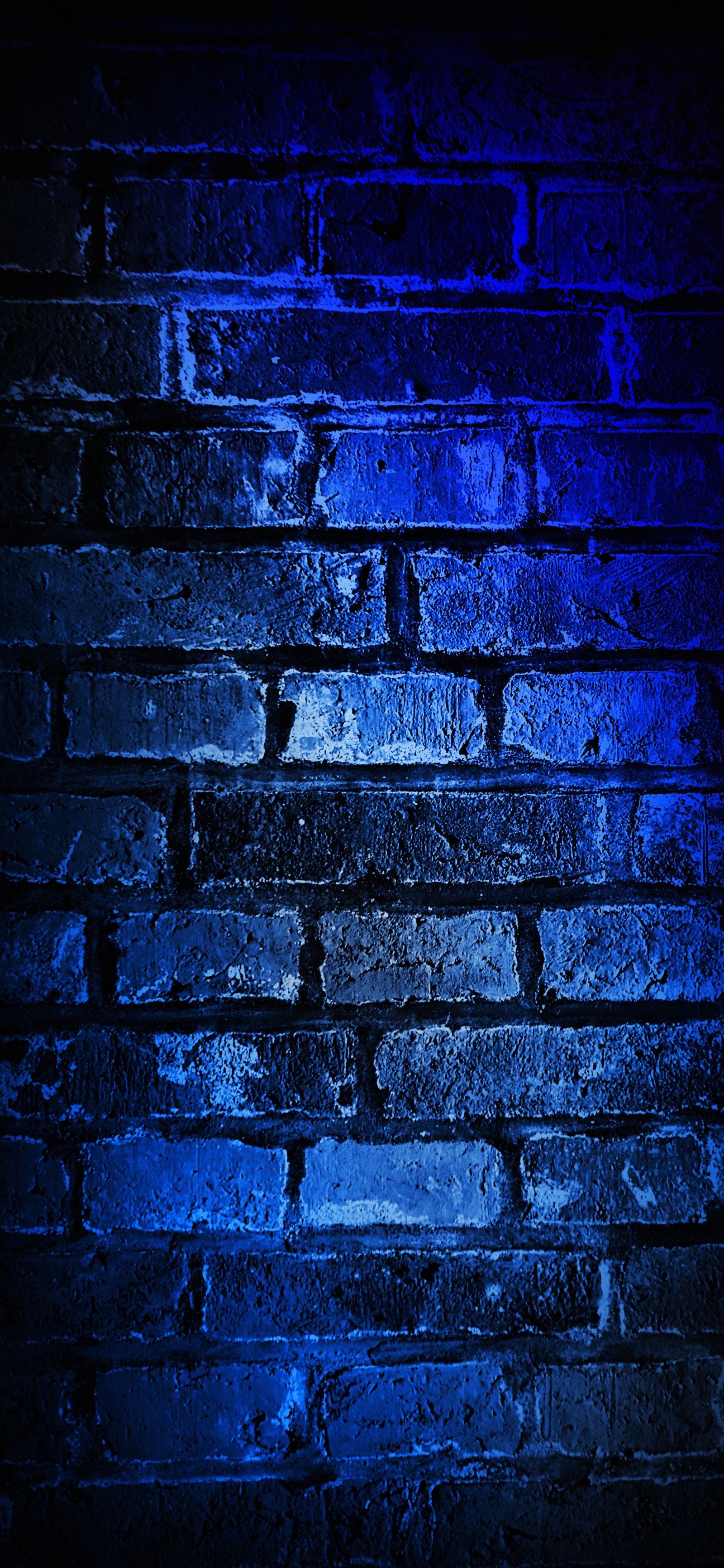 Un primer plano de una pared de ladrillos con luz azul. (pared, ios, azul, púrpura, ladrillo)