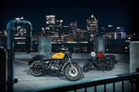 Royal Enfield Meteor 350 Motorräder gegen eine Stadt-Skyline bei Nacht