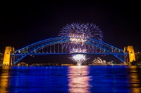 Puente de la Bahía de Sídney iluminado con fuegos artificiales y la Ópera de Sídney de noche