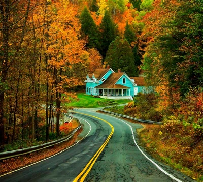 Charmantes blaues Haus umgeben von lebhaften herbstlichen Laub entlang einer kurvenreichen Straße