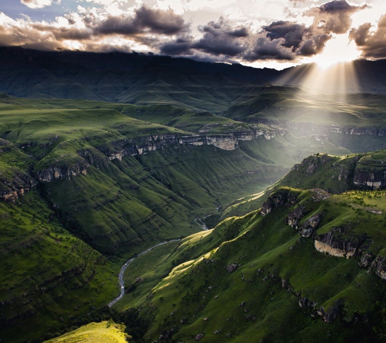 Une vue d'une vallée avec une rivière qui la traverse (paysage, montagne, ciel)