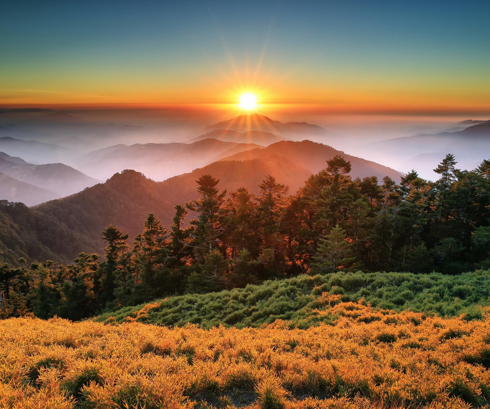 Una vista de una cordillera con el sol poniéndose sobre las montañas (china, montaña, atardecer, taiwán, parque nacional taroko)