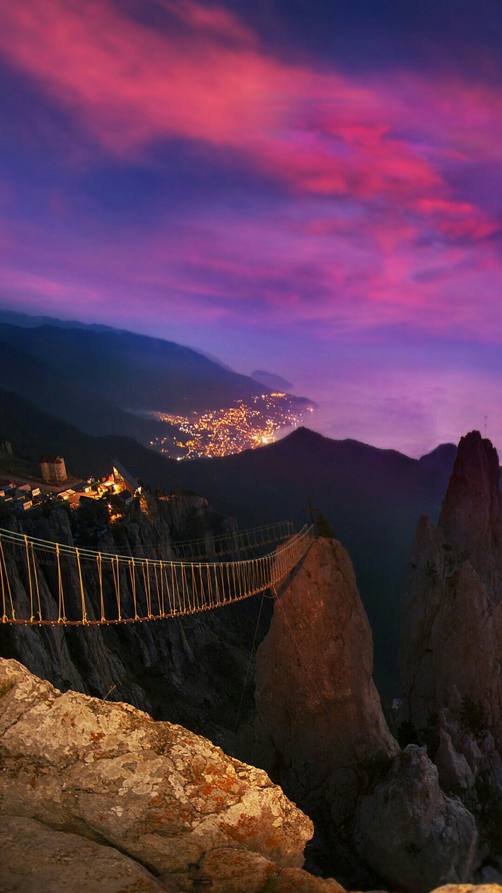 Araffe suspension bridge over a mountain with a city in the distance (color, hd abstract, magic)