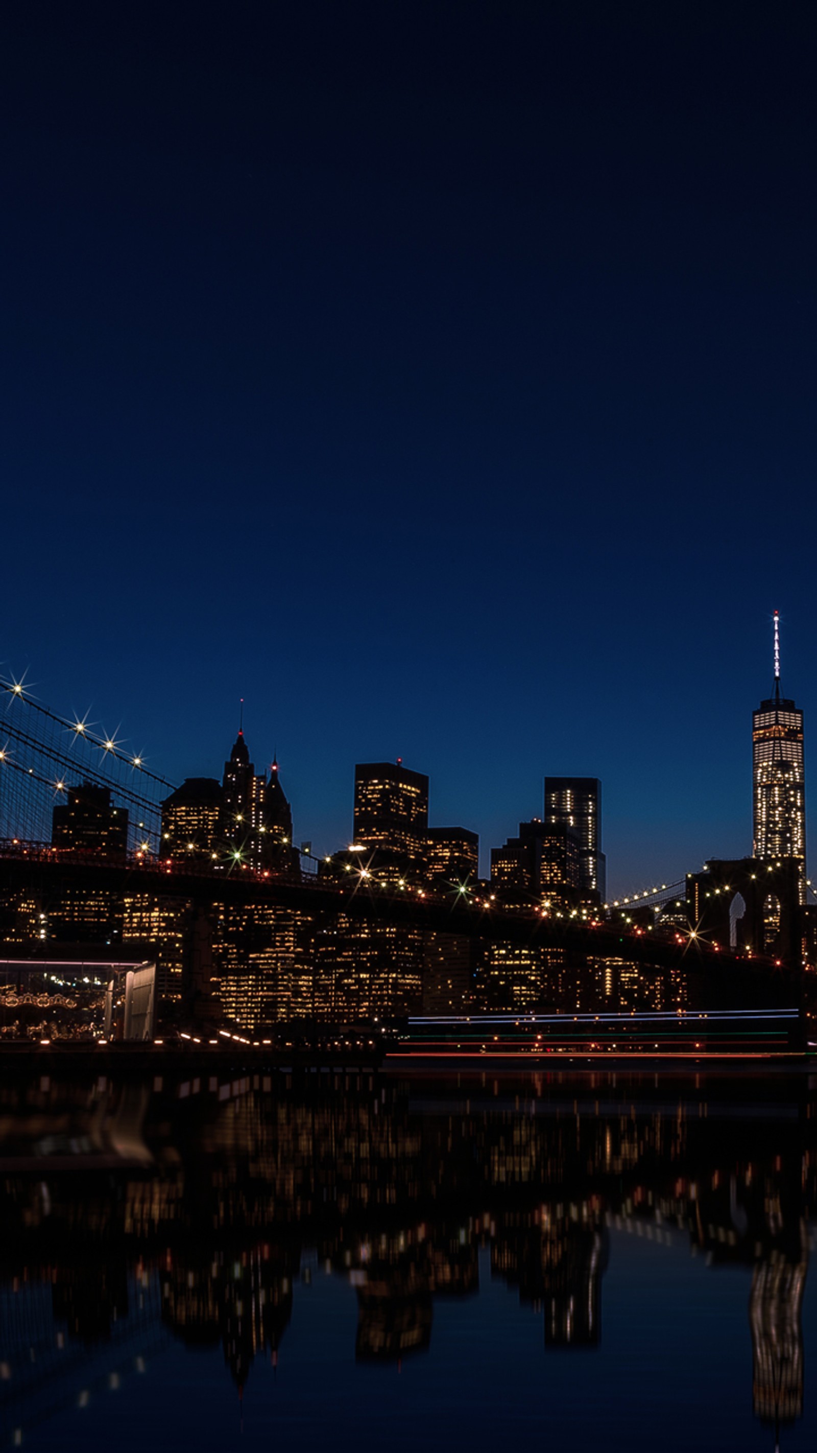 Vue aérienne d'un panorama urbain de nuit avec un bateau dans l'eau (ville, new york, nuit, réflexion)