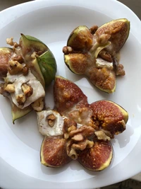 Figues farcies aux noix et au fromage sur une assiette blanche