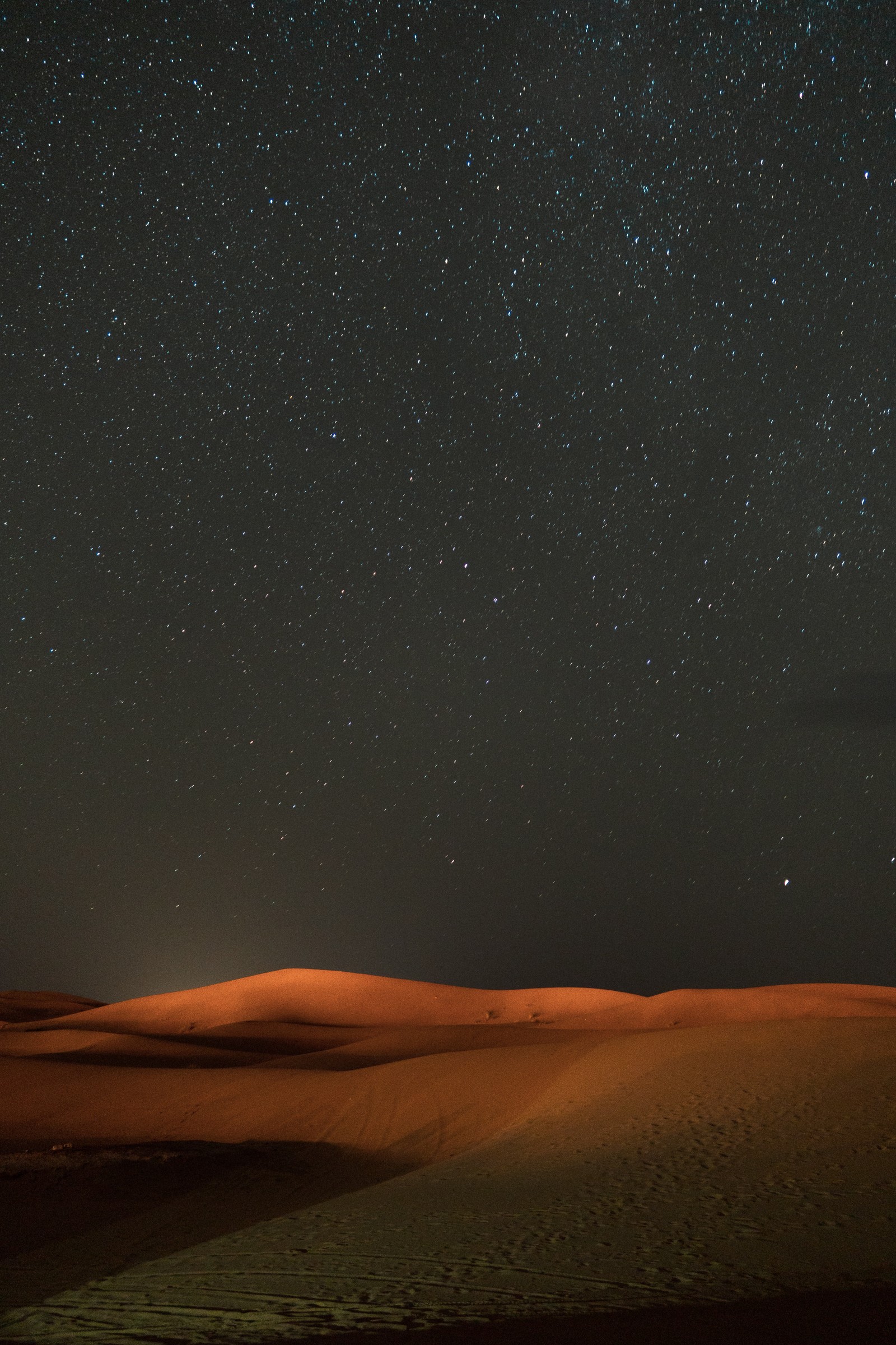 Céu estrelado sobre uma paisagem desértica com um cavalo solitário (ambiente natural, atmosfera, paisagem, horizonte, forma de relevo eólico)