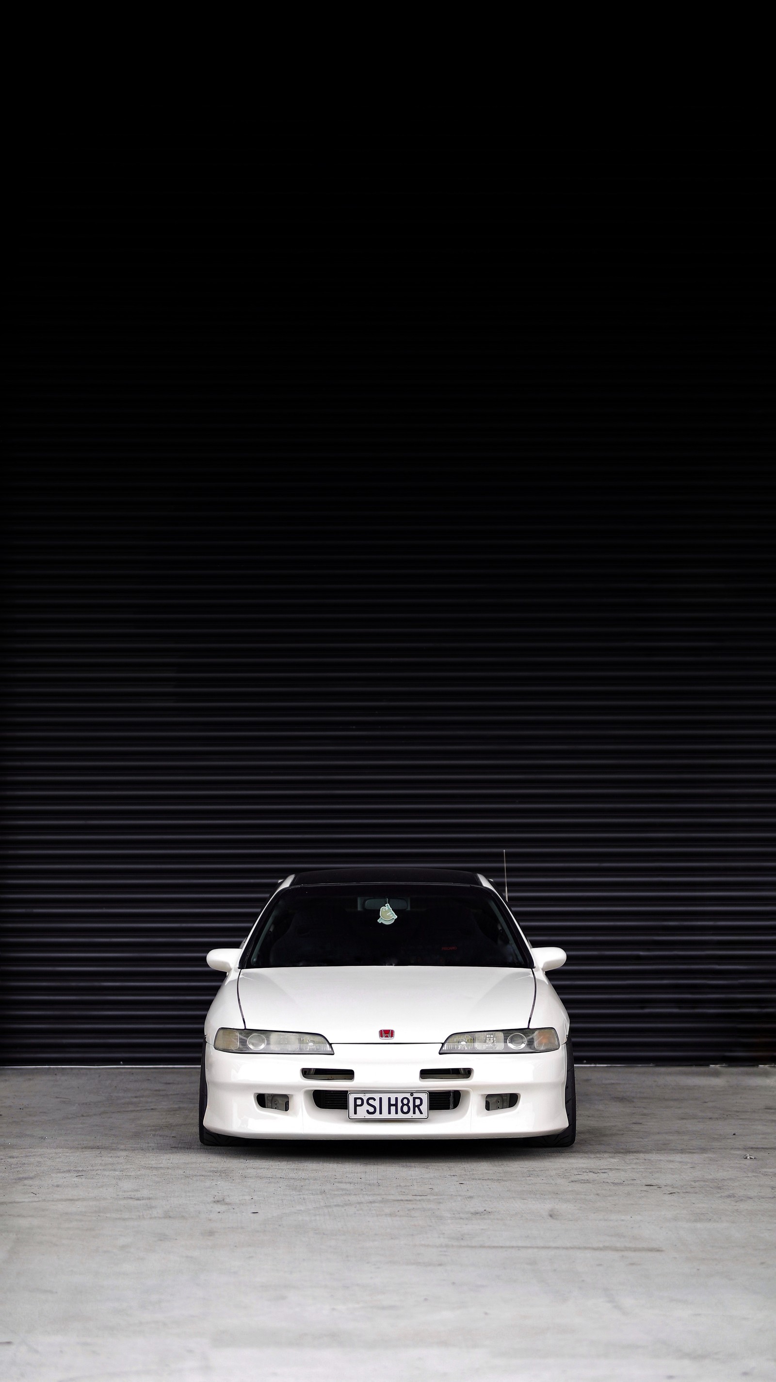 Arafed white car parked in front of a garage door (sports car, car, coup, automotive lighting, sedan)