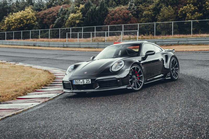 Черный porsche 911 gts, едущий по трассе с деревьями на заднем плане (brabus 820 coupé, porsche 911 turbo s купе, 2022, машины, обои 4k)