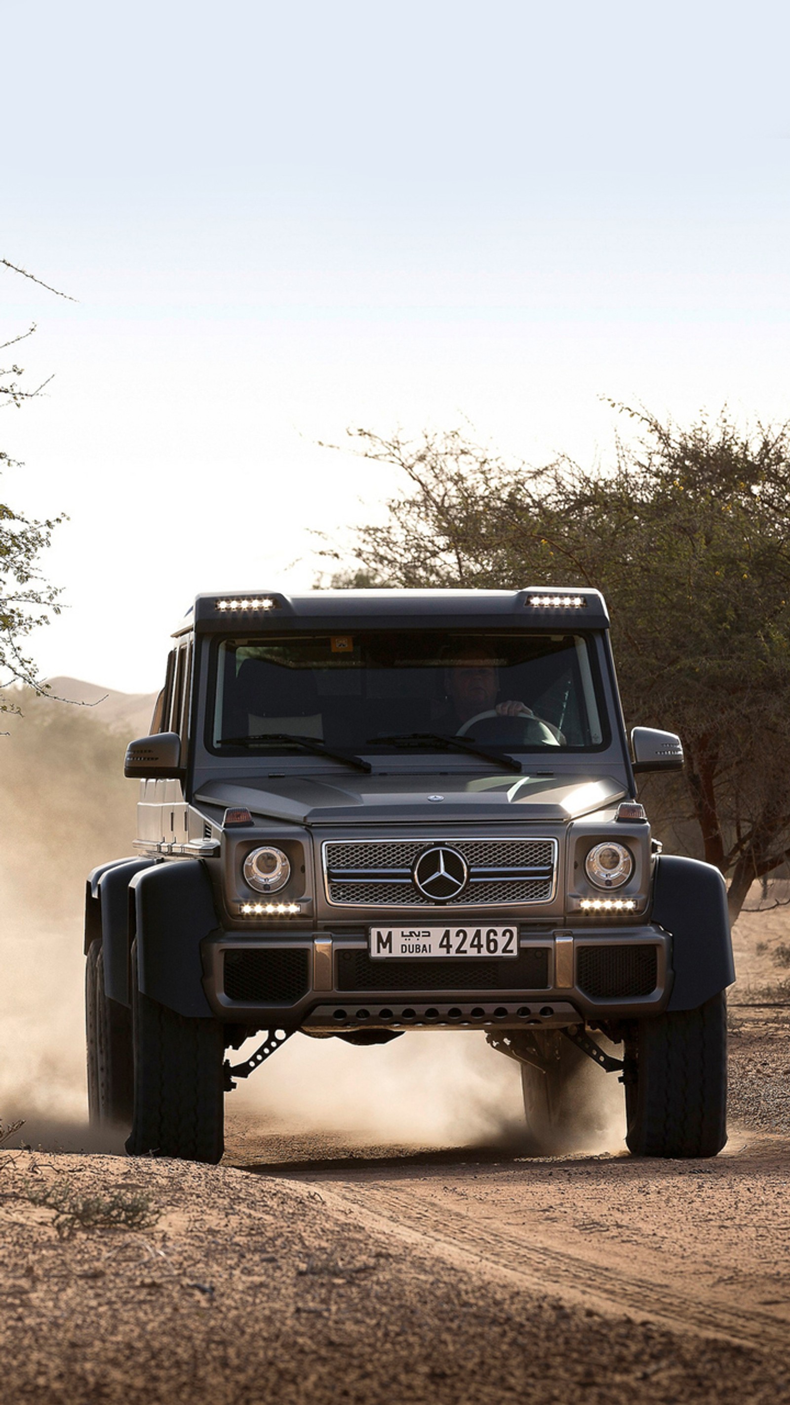 Аэрофотоснимок автомобиля, едущего по пыльной дороге (6x6, g63, mercedes)