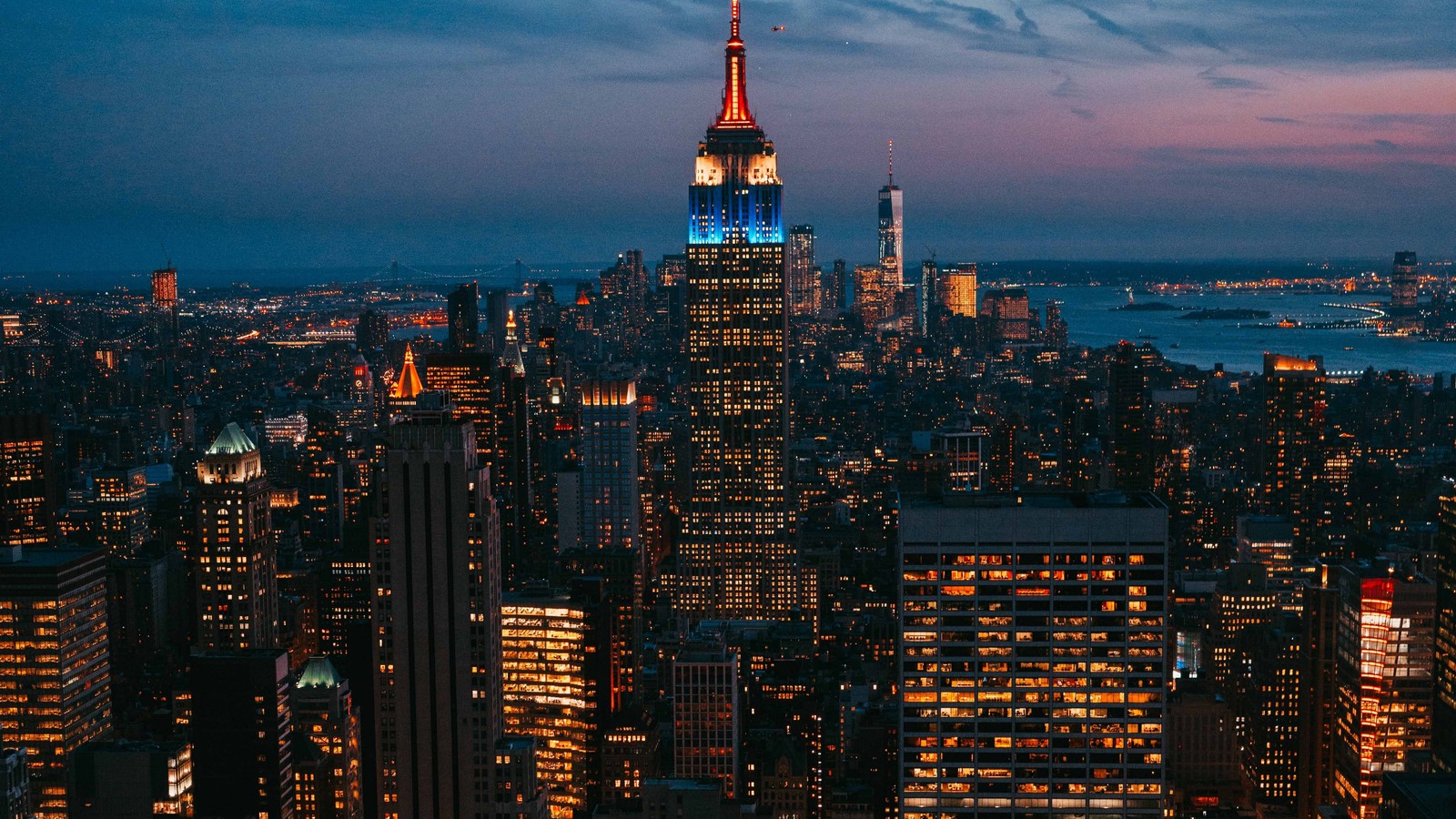 Vue aérienne d'une ville la nuit avec des lumières bleues et rouges (paysage urbain, ville, métropole, zone urbaine, horizon)